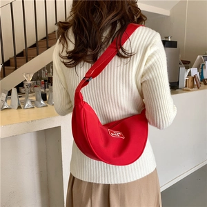 Bright red crescent crossbody waist bag with adjustable wide shoulder strap and logo