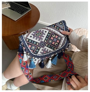 Detail of bohemian woven crossbody bag with colorful tassels and geometric patterns