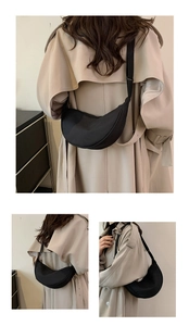 Borsa a tracolla a mezzaluna nera in nylon minimalista abbinata a un trench beige