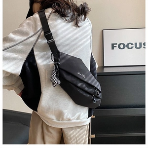 Detailed view of black nylon crossbody bag with embroidery and checkerboard pendant