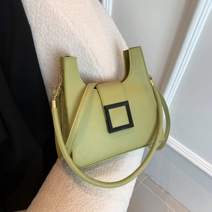 Chic light green crossbody bag with lychee grain texture and square buckle on a chair
