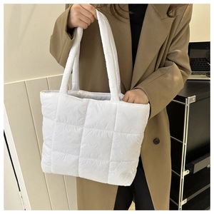 Close-up of white quilted tote bag featuring padded nylon material and soft texture