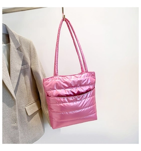 Detail of pink quilted tote bag with metallic finish and visible stitching on straps