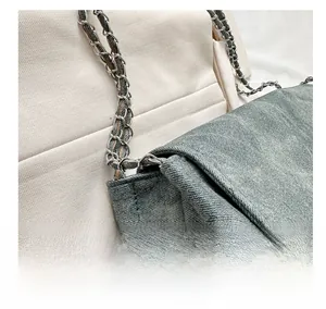 Detail of vintage denim shoulder bag featuring high-quality chain strap and woven fabric