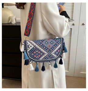Detail of bohemian crossbody bag with ethnic embroidery and colorful fringe tassels