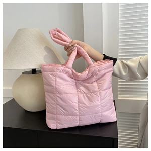 Close-up of pink quilted puffer tote bag with glossy finish and soft padding texture