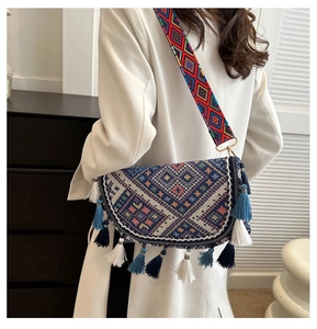 Close-up of bohemian shoulder bag with geometric patterns and colorful tiered tassels