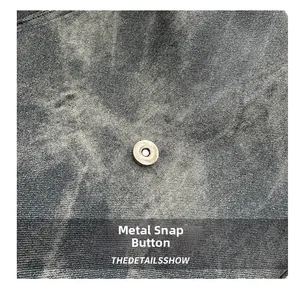 Close-up of the silver magnetic metal clasp on textured gray washed denim tote bag
