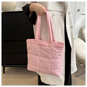 Detail of pink quilted down puffer tote bag featuring soft square stitching and top handles
