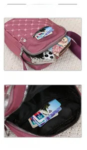 Detail of purple nylon crossbody bag with star embroidery and multiple zipper pockets