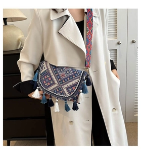 Close-up of bohemian shoulder bag featuring geometric embroidery and vibrant layered tassels
