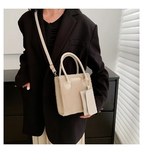 Detail view of beige plush crossbody bag with leather handles and a mini round coin purse