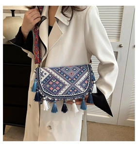 Detail of bohemian woven crossbody bag with colorful tassels and geometric patterns