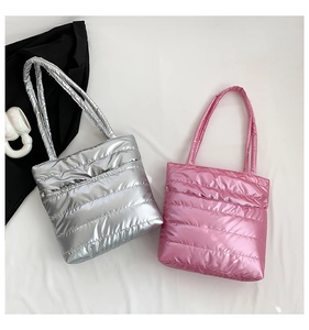 Detailed view of silver and pink quilted puffer tote bags with metallic finish texture