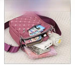 Detail view of burgundy crossbody bag interior showing multiple spacious storage compartments