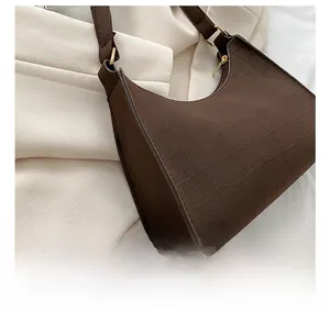 Detailed view of dark brown faux crocodile leather texture and fine stitching on hobo bag