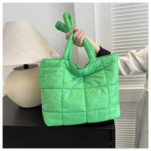 Close-up of bright green quilted nylon tote bag with soft padded handle detail