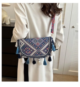 Detailed shot of ethnic crossbody bag with geometric embroidery and colorful tassels