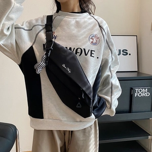 Minimalist black nylon crossbody chest bag with adjustable strap and white text print