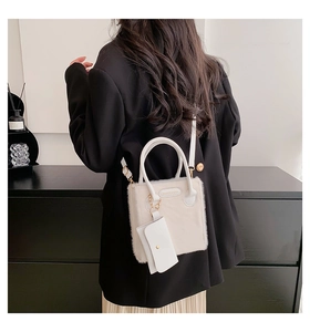 Detail of white faux fur tote bag with mini pouch on black blazer for contrast