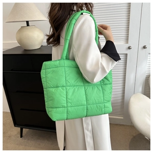 Macro detail of bright green quilted puffer tote bag with square stitching texture