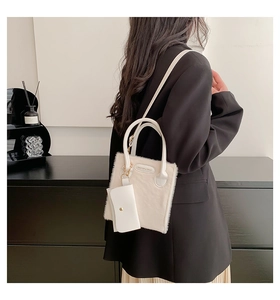 Detail of a creamy white plush crossbody bag with faux fur texture and mini pouch accessory