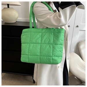 Close-up of bright green quilted puffer tote bag with large square stitching details