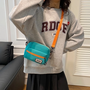 Minimalist blue canvas crossbody bag with orange strap and dual zippers for women