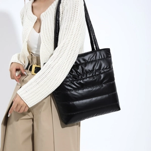 Large black quilted puffer tote bag for women with glossy finish and dual shoulder straps