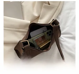 Top view of dark brown frosted baguette bag interior with phone and cosmetics