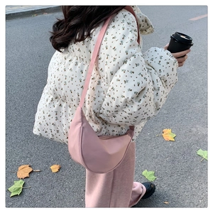 Borsa a tracolla rosa a mezzaluna mostrata in una scena di strada autunnale da una modella