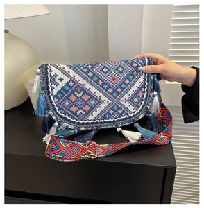 Detailed close-up of ethnic crossbody bag featuring blue tassels and geometric woven patterns