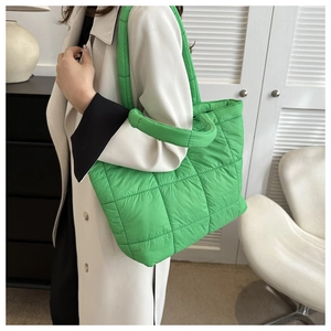 Detailed shot of bright green quilted puffer tote bag with wide padded shoulder straps