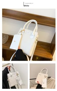 Detail view of white plush crossbody bag with PU handle and small zipper pouch