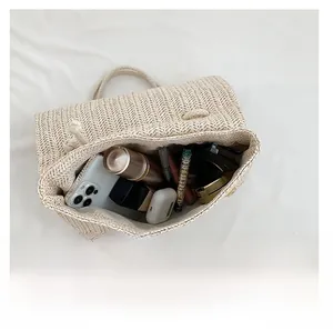 Detail view showing interior capacity of the beige woven tote bag with daily essentials