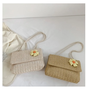 Close-up of woven tote bags in beige and khaki with decorative yellow fabric flowers