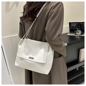 White faux leather chain shoulder bag shown in a professional office setting