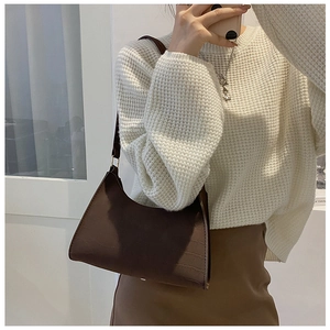 Detailed close-up showing the dark brown crocodile pattern texture of the faux leather bag
