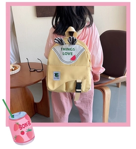 Detail view of yellow cartoon children's backpack with cute rabbit ears and letter prints