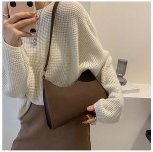 Detail shot of brown crocodile pattern underarm bag with vintage aesthetic and slim strap