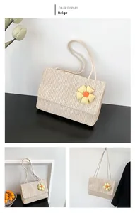 Detail view of beige straw woven shoulder bag with a yellow plaid flower accessory