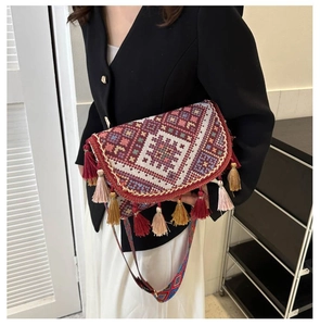 Detailed close-up of ethnic woven crossbody bag with colorful tassels and geometric patterns