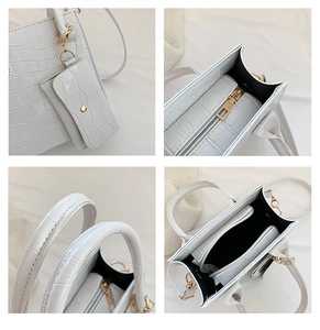 Detailansicht der weißen Krokodil-Textur und goldener Hardware an der Damenhandtasche
