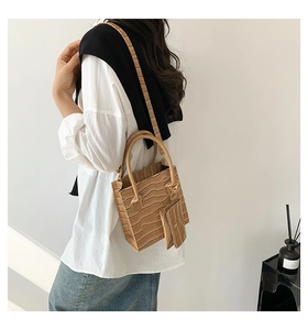 Details der khakifarbenen Handtasche mit Kroko-Prägung und passendem Mini-Nackenbeutel