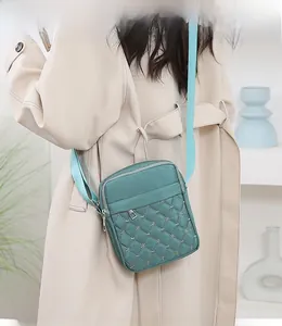 Detail view of green quilted oxford fabric crossbody bag with embroidered star patterns