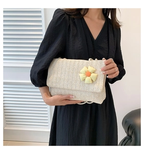 Detail of cream woven tote bag featuring a yellow checkered sunflower charm decoration