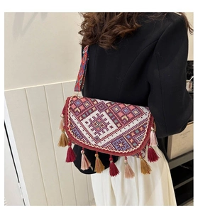 Detailed shot of ethnic woven crossbody bag with colorful tassels and geometric patterns