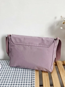 Detailed view of light purple canvas messenger bag with durable wide shoulder strap