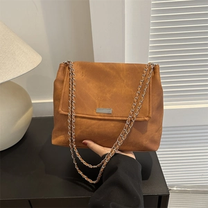 Brown vintage suede shoulder bag with a silver chain strap and minimalist metal plate
