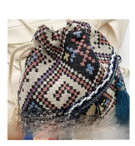 Detailed close-up of ethnic geometric woven bucket bag with cotton drawstring and blue tassel